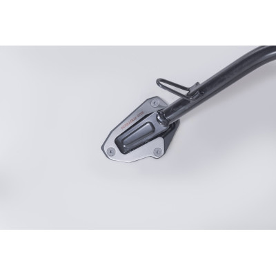 Nástavec pro nohu bočního stojanuTento odolný nástavec patky má velkou kontaktní plochu pro lepší stabilitu, a to i na nerovném 